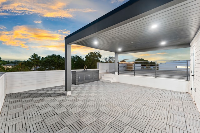 patio terrace at dusk with sink and exterior kitchen