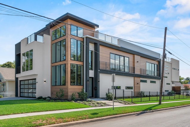 view of side of home featuring a garage, a yard, and a balcony