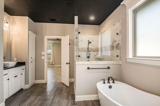 bathroom featuring separate shower and tub, hardwood / wood-style flooring, and vanity