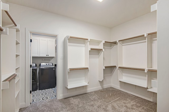 spacious closet featuring light carpet and separate washer and dryer