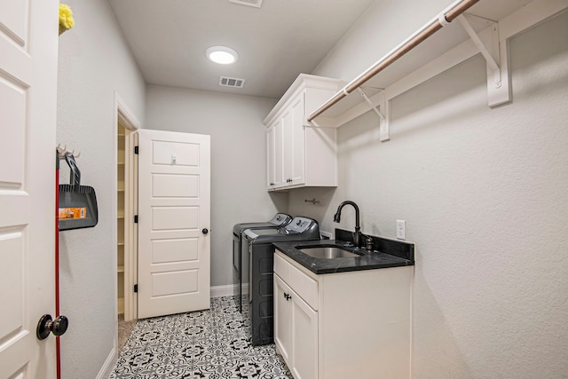 laundry area featuring cabinets, sink, and washer and clothes dryer