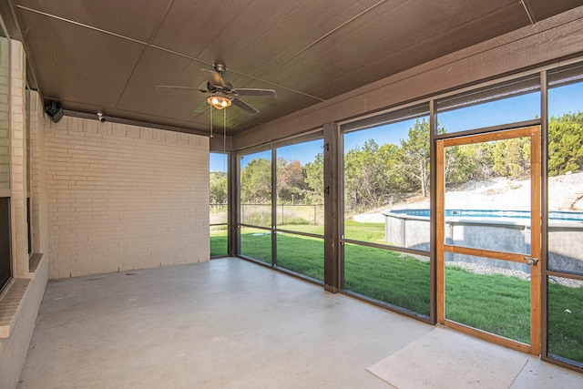 unfurnished sunroom featuring ceiling fan