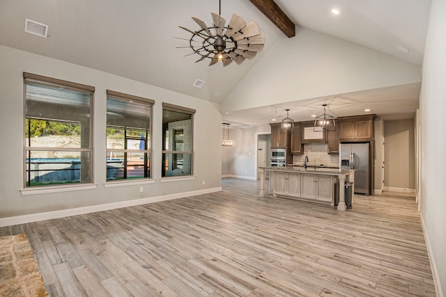 interior space featuring light hardwood / wood-style floors, beamed ceiling, ceiling fan, sink, and high vaulted ceiling