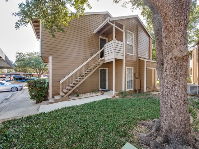 view of property with a front yard and central air condition unit