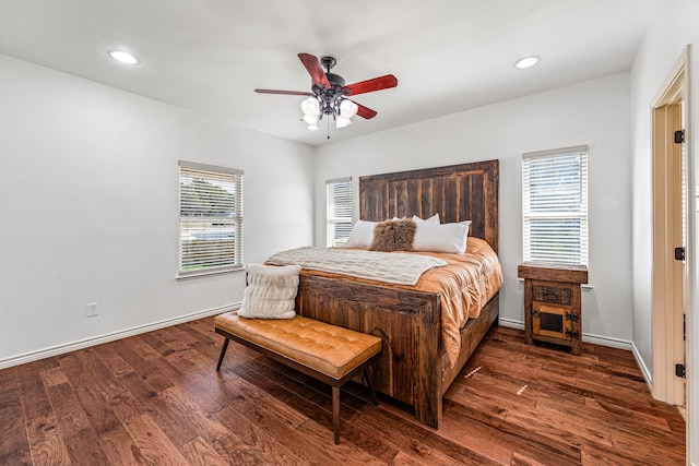 bedroom featuring dark hardwood / wood-style flooring, multiple windows, and ceiling fan