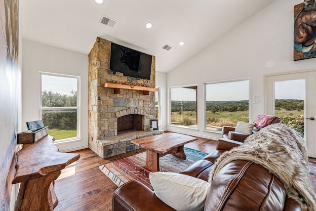 living room featuring high vaulted ceiling, a fireplace, a wealth of natural light, and hardwood / wood-style floors