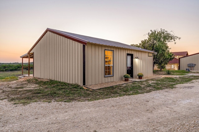 property exterior at dusk featuring an outbuilding