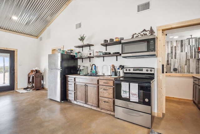 kitchen with appliances with stainless steel finishes, high vaulted ceiling, and sink