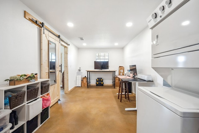 interior space featuring stacked washer / dryer and a barn door