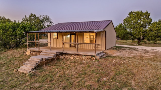 back house at dusk featuring a lawn