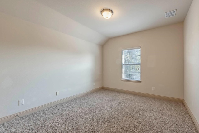 empty room with lofted ceiling and carpet flooring