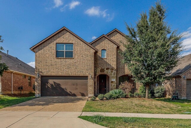 941 Lake Meadow Ln, Little Elm, TX 75068 - view of front of home with a garage, stone siding, a front yard, brick siding, and concrete driveway