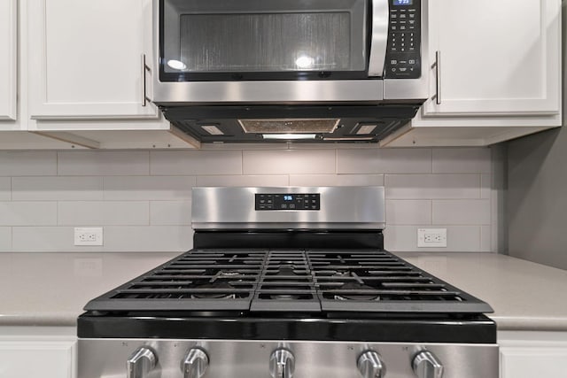 kitchen featuring backsplash, white cabinetry, and appliances with stainless steel finishes