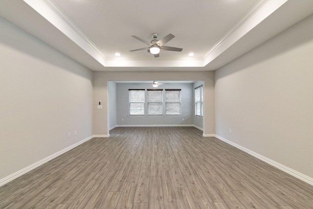 unfurnished living room featuring ceiling fan, wood-type flooring, and a raised ceiling