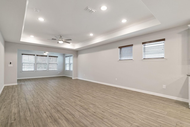 interior space with a raised ceiling and light wood-type flooring