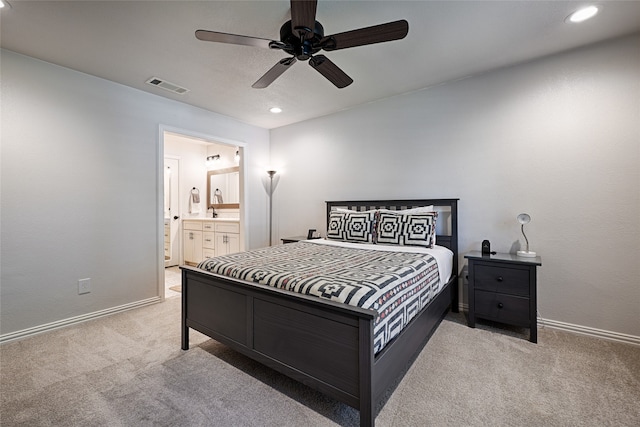 carpeted bedroom with ensuite bathroom and ceiling fan