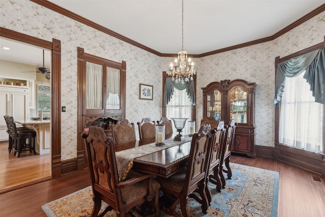903 N College St, Mckinney, TX 75069 - dining space featuring crown molding, wallpapered walls, ceiling fan with notable chandelier, dark wood finished floors, and baseboards