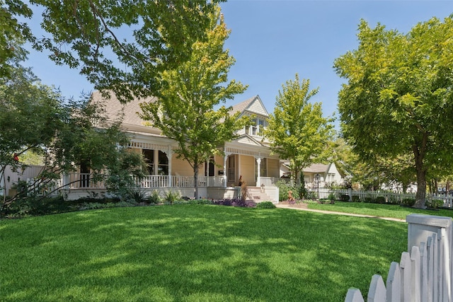 view of gate with a fenced front yard and a porch