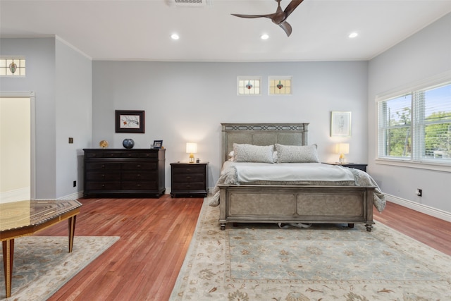 bedroom featuring crown molding, light wood-type flooring, and ceiling fan