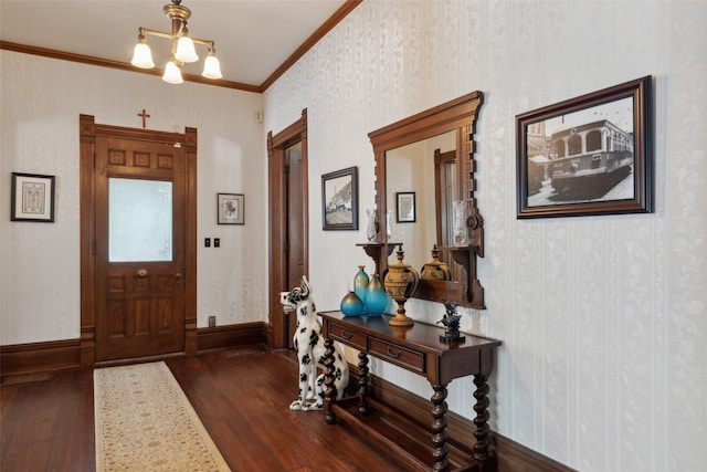 entrance foyer featuring ornamental molding, a notable chandelier, and dark hardwood / wood-style flooring