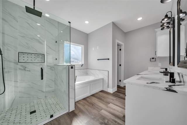 bathroom with shower with separate bathtub, hardwood / wood-style flooring, and vanity