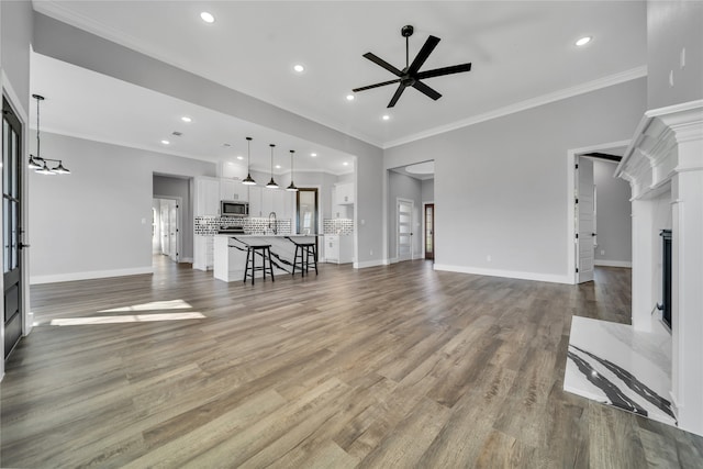 living room featuring ceiling fan, hardwood / wood-style floors, and ornamental molding