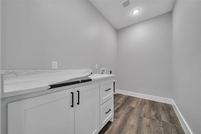 interior space with cabinets, dark hardwood / wood-style floors, hookup for a washing machine, and electric dryer hookup