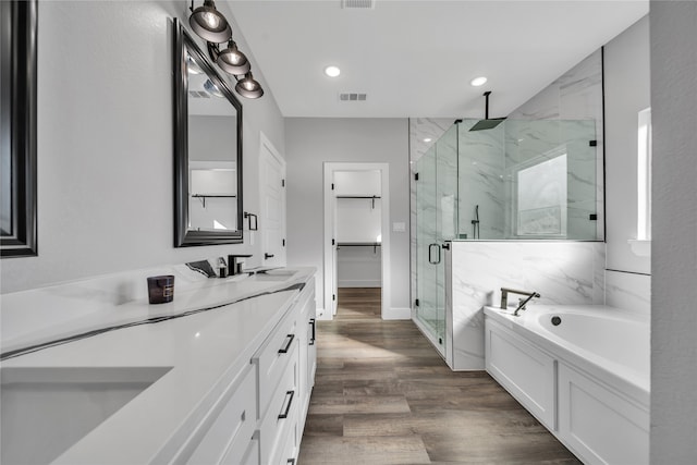 bathroom featuring wood-type flooring, separate shower and tub, and vanity