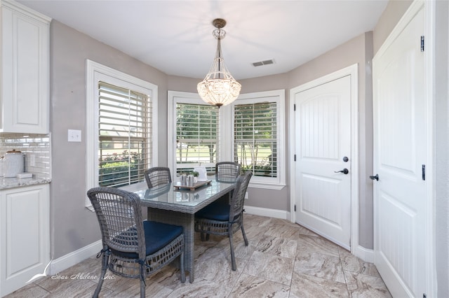 dining room featuring plenty of natural light and an inviting chandelier