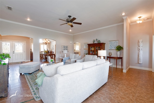 tiled living room with ceiling fan with notable chandelier and crown molding