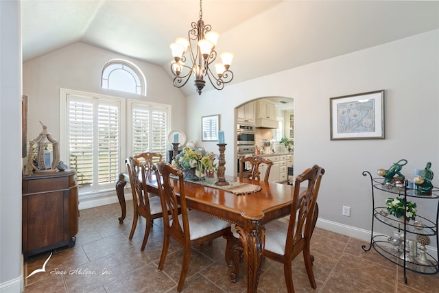 dining area featuring a notable chandelier, vaulted ceiling, and dark tile patterned floors