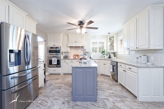 kitchen with stainless steel appliances, white cabinets, and a center island