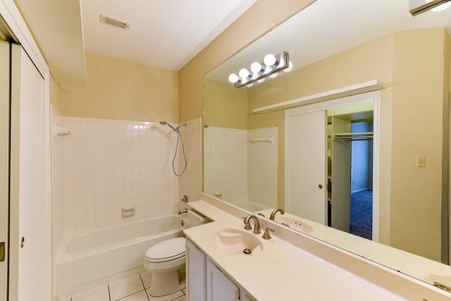 full bathroom featuring tiled shower / bath, vanity, toilet, and tile patterned flooring