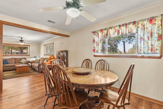 dining room with plenty of natural light, light hardwood / wood-style floors, and crown molding