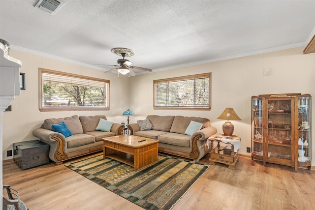 living room with ornamental molding, light wood-type flooring, and ceiling fan