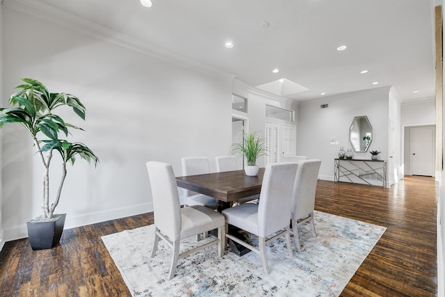 dining space featuring a skylight, dark hardwood / wood-style floors, and ornamental molding