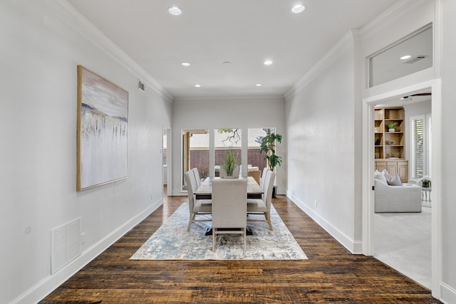 dining room with built in shelves, dark hardwood / wood-style flooring, and ornamental molding