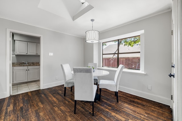 dining room featuring dark hardwood / wood-style flooring, ornamental molding, and sink