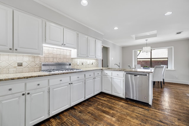 kitchen featuring white cabinets, decorative light fixtures, dark hardwood / wood-style floors, and appliances with stainless steel finishes