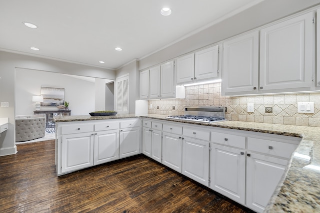 kitchen with stainless steel gas stovetop, dark hardwood / wood-style flooring, white cabinetry, and kitchen peninsula