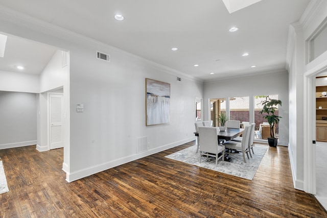 dining area with a skylight, dark hardwood / wood-style floors, and ornamental molding