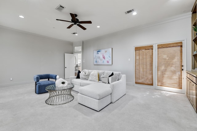 living room with ceiling fan, ornamental molding, and light carpet