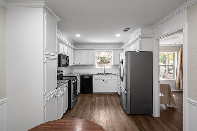 kitchen with dark hardwood / wood-style flooring, sink, ornamental molding, white cabinets, and black appliances