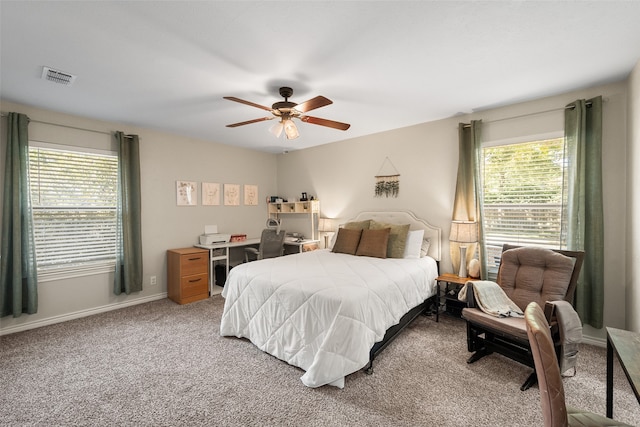 bedroom featuring light carpet, multiple windows, and ceiling fan