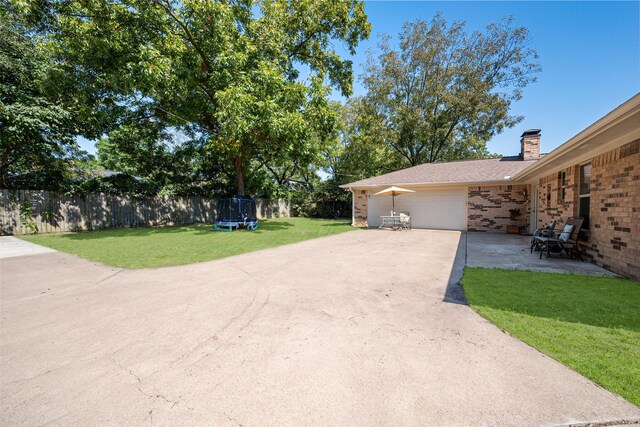 single story home featuring a trampoline and a front lawn