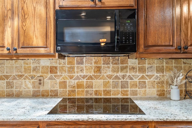7710 Valley Ridge Dr, Northlake, TX 76247 - kitchen view of black appliances, brown cabinets, tasteful backsplash, and light stone counters