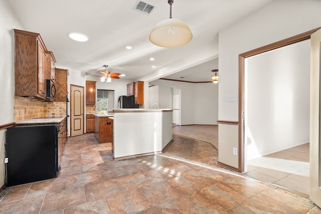 kitchen featuring ceiling fan, light stone countertops, backsplash, and decorative light fixtures