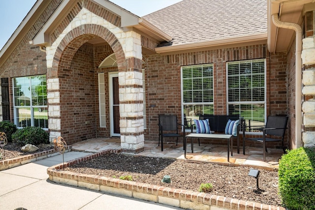 7710 Valley Ridge Dr, Northlake, TX 76247 - view of exterior entry featuring brick siding, roof with shingles, and a patio area