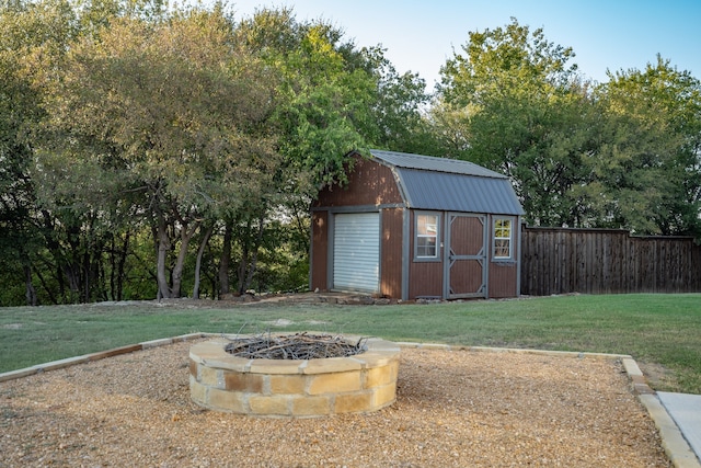 view of outdoor structure with a lawn and a fire pit