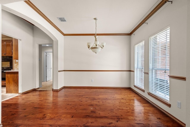 7710 Valley Ridge Dr, Northlake, TX 76247 - unfurnished dining area with crown molding, a chandelier, arched walkways, light wood-type flooring, and baseboards